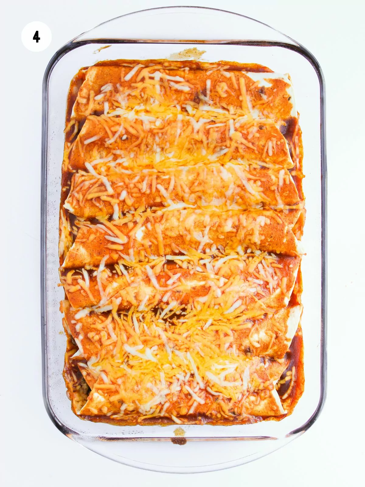 baked cheesy enchiladas in a glass dish