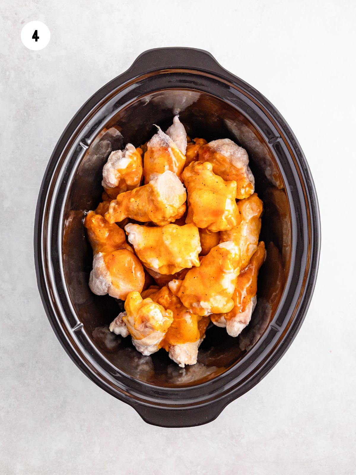 sauce poured on the raw wings