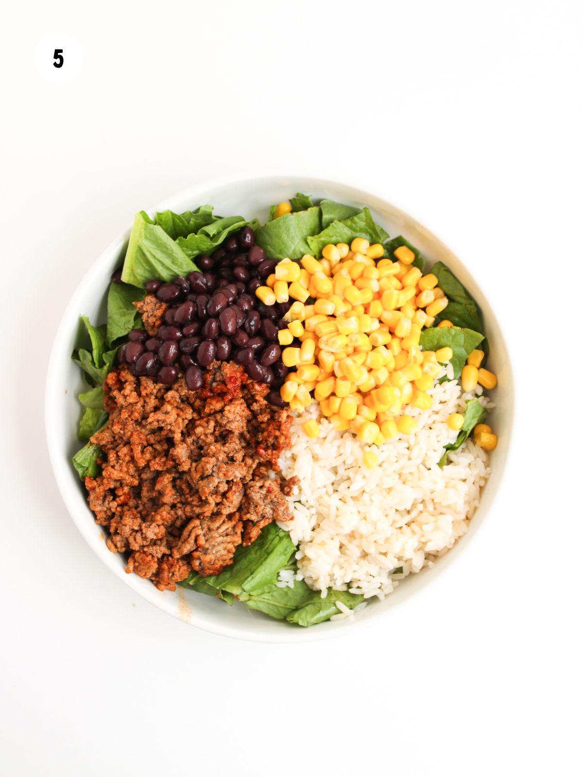 ground beef, black beans, rice, and corn on lettuce