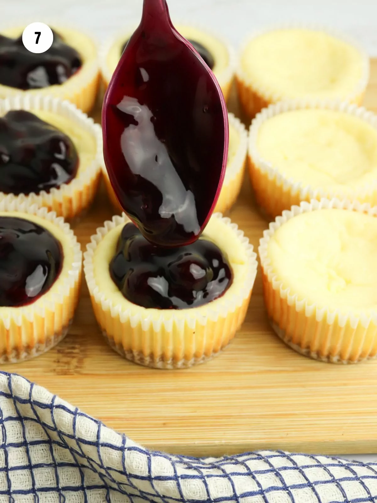 blueberry pie filling spooned on top of the baked cheesecakes