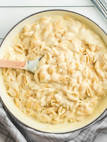 mac and cheese in Dutch Oven with wooden spoon.