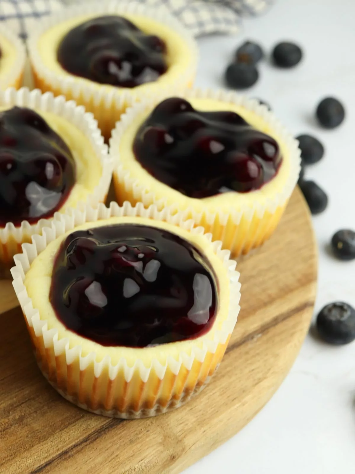 Mini Blueberry Cheesecakes on a round wood board