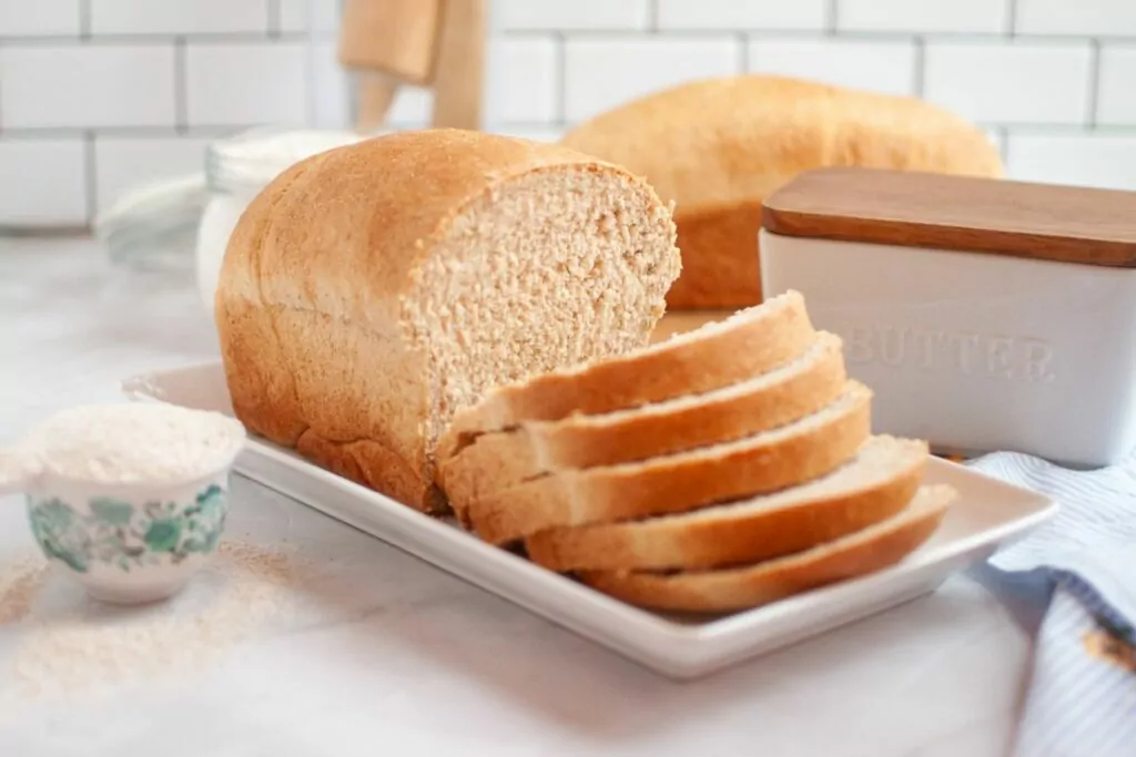 loaf of Honey Wheat Bread that has been sliced halfway