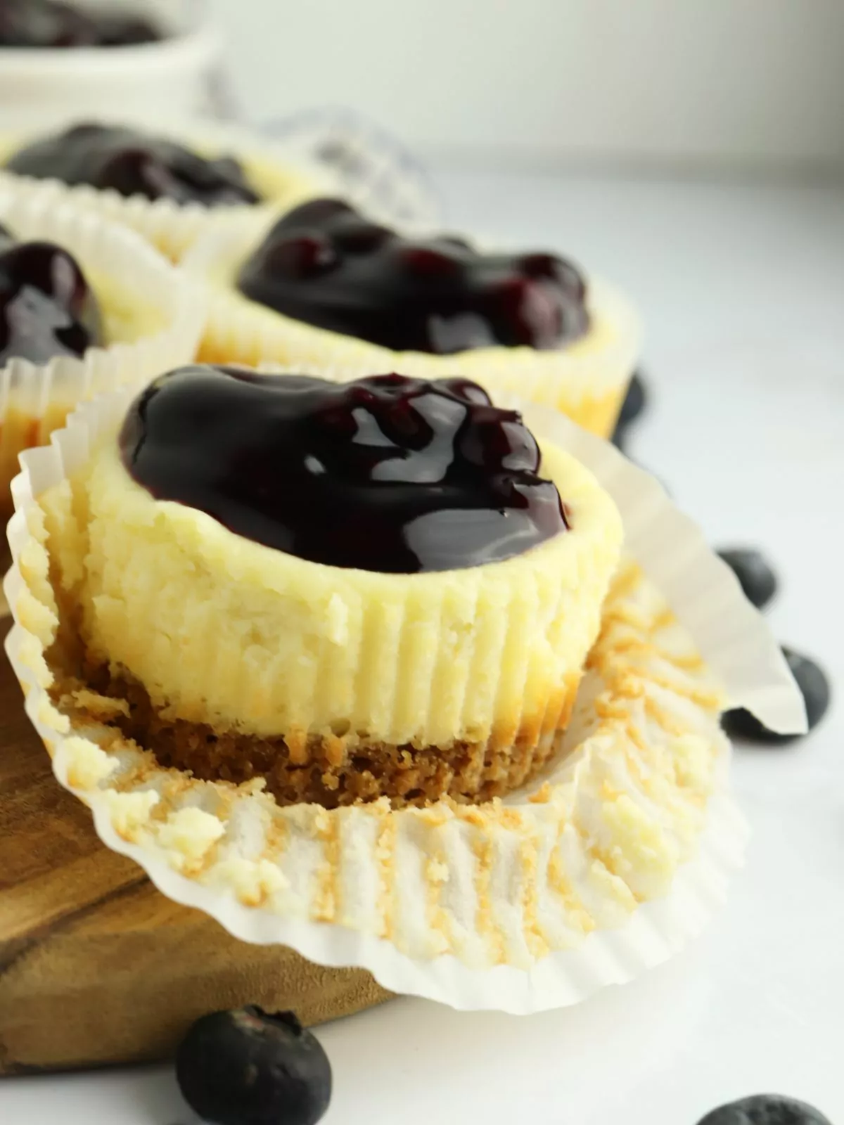 close up of a mini blueberry cheesecake with the wrapper pulled off.