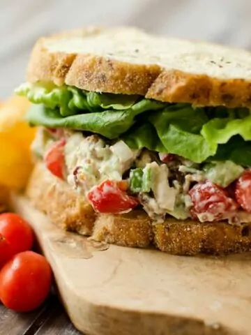 chicken salad sandwich on board with tomatoes MSN.