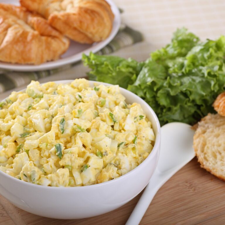 prepared egg salad with mayonnaise and dijon mustard in white bowl.