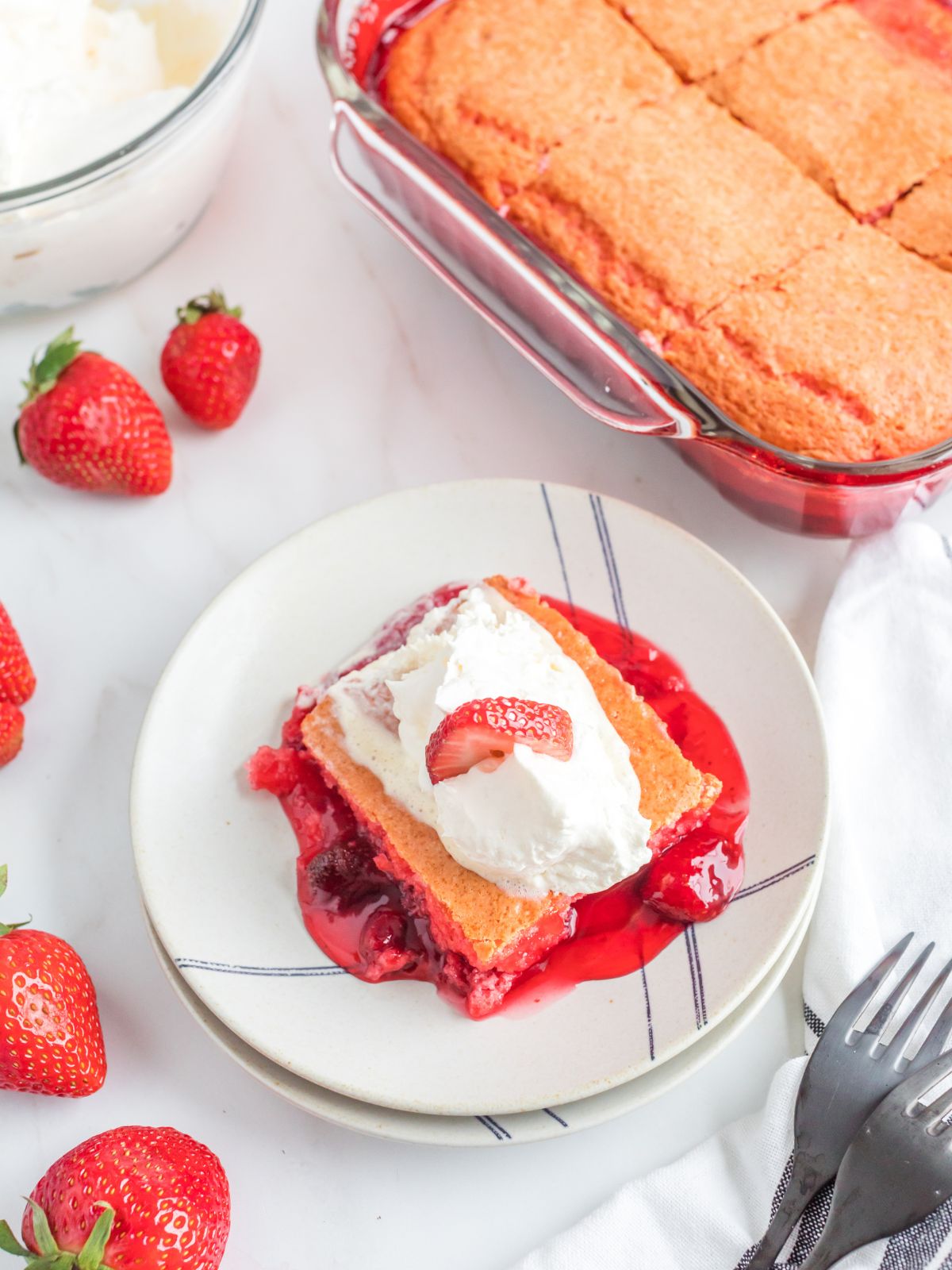 slice of Strawberry Dump Cake topped with Cool Whip