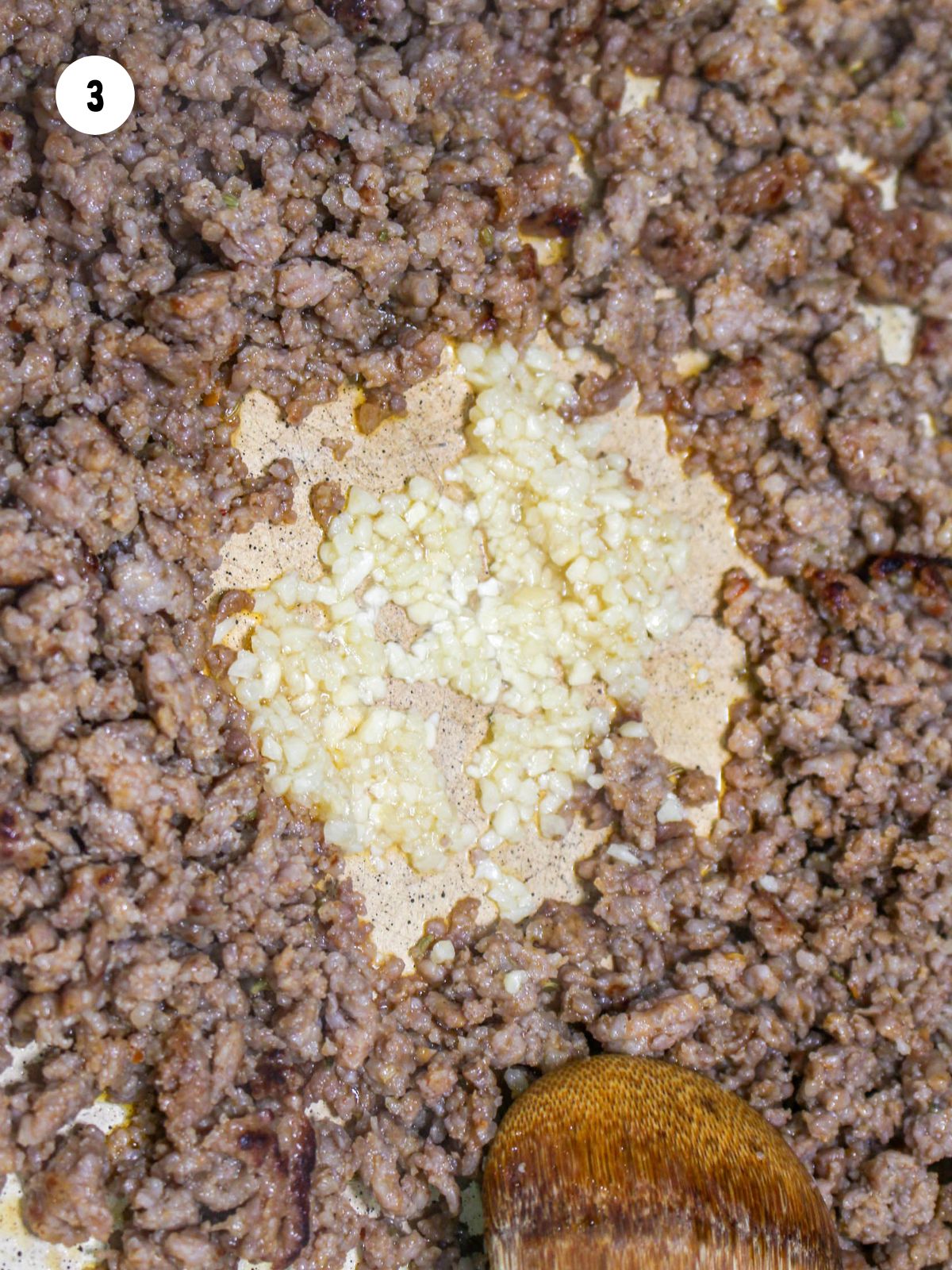 minced garlic added to the browned sausage