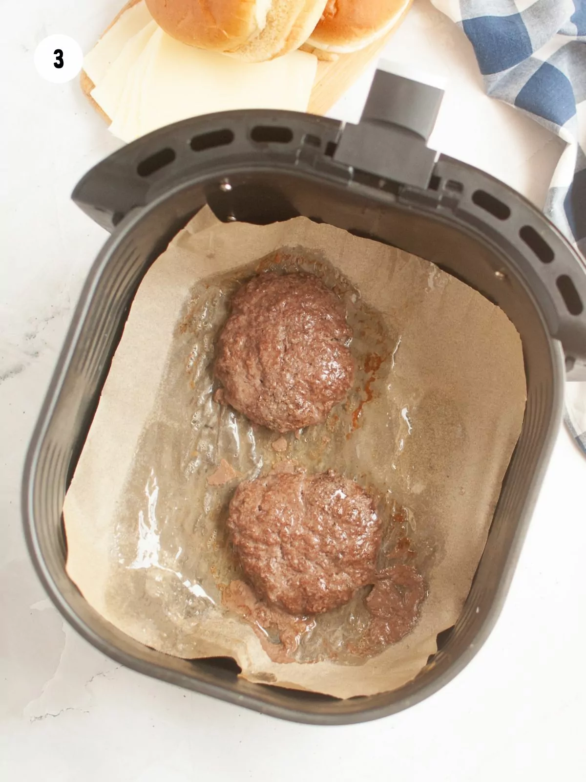 cooked burger patties in the air fryer basket