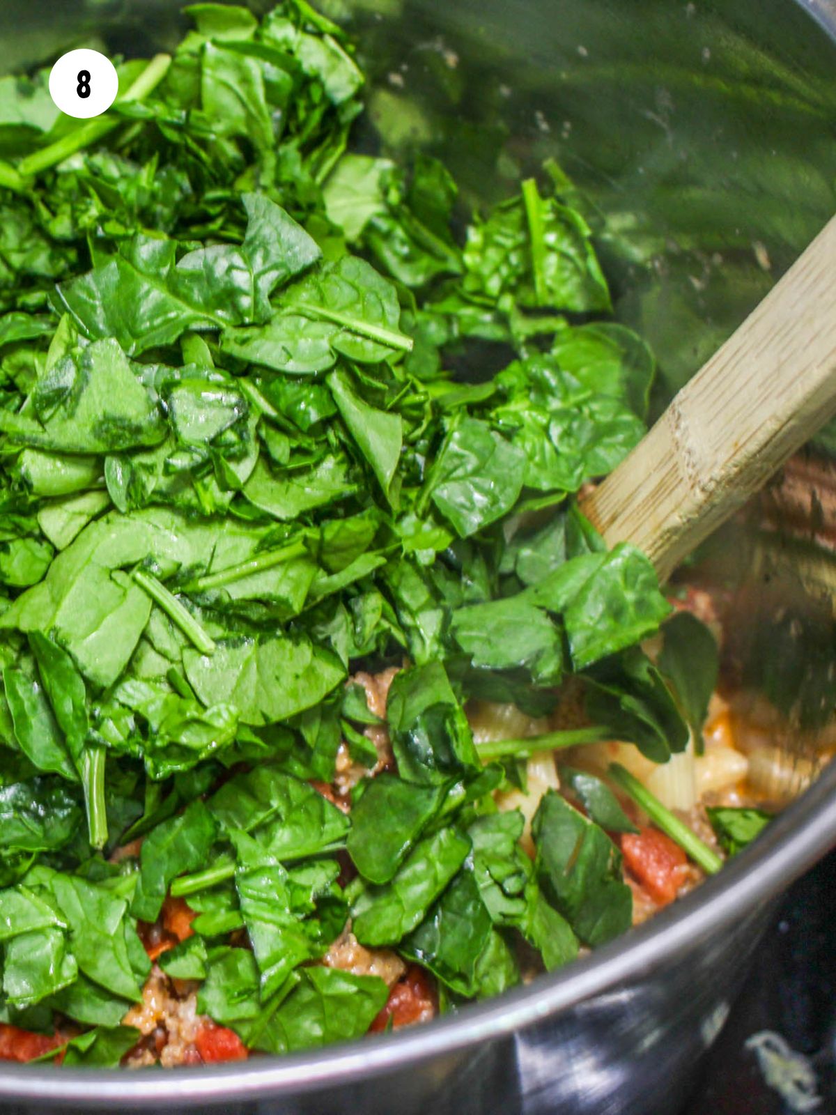 fresh chopped baby spinach added to the sauced pasta