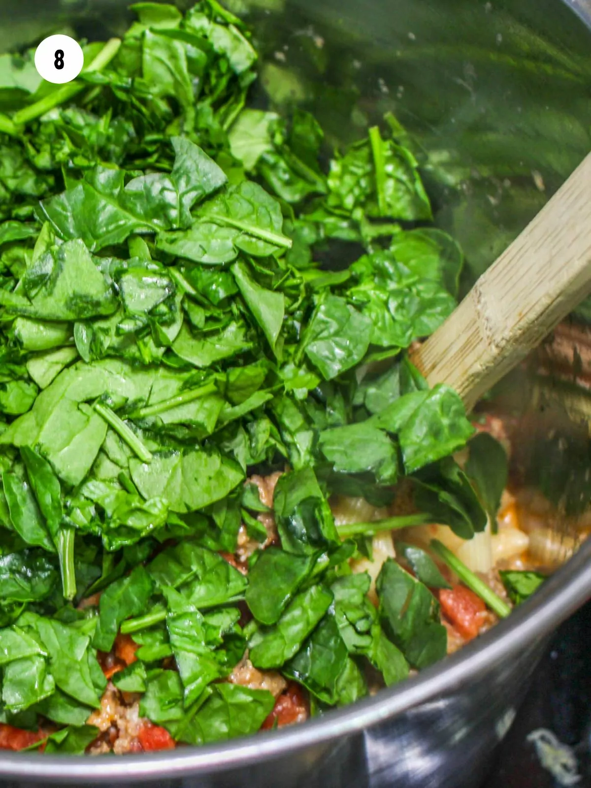 fresh chopped baby spinach added to the sauced pasta