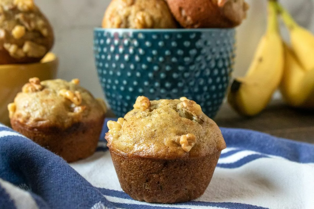 Banana Nut Muffins with fresh bananas in the background