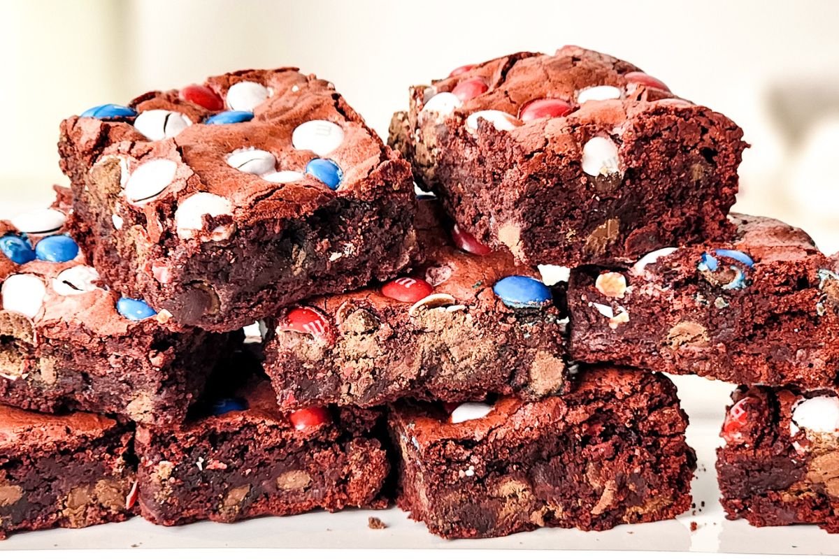 brownies with red white and blue m&M's stacked up on a platter