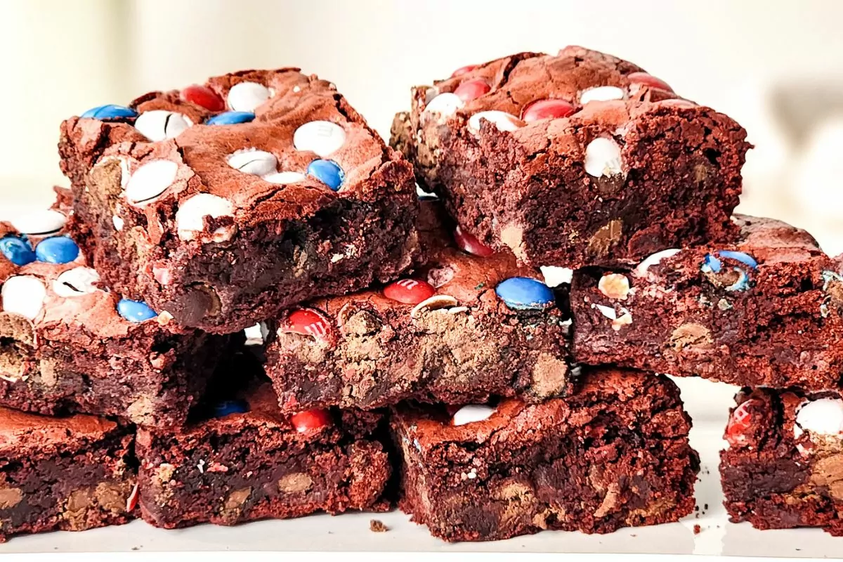 brownies with red white and blue m&M's stacked up on a platter