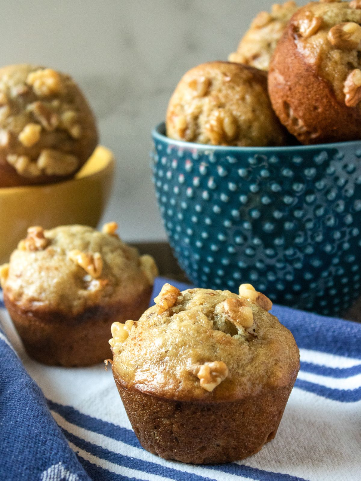 Banana Muffins on a striped towel and in a teal bowl