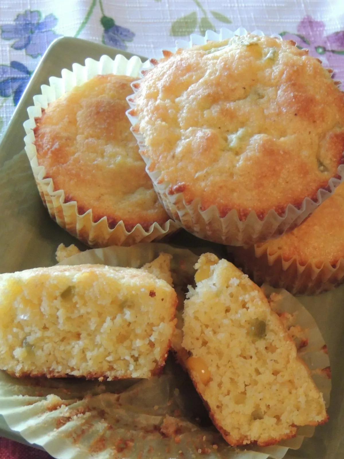 Jiffy box corn muffins baked on plate with one sliced opened.