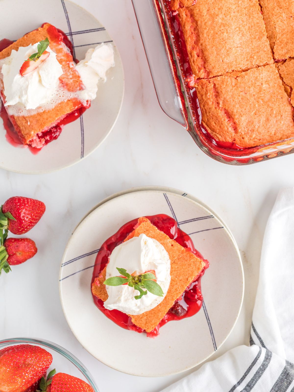 overhead view of cake topped with cool whip and fresh strawberry