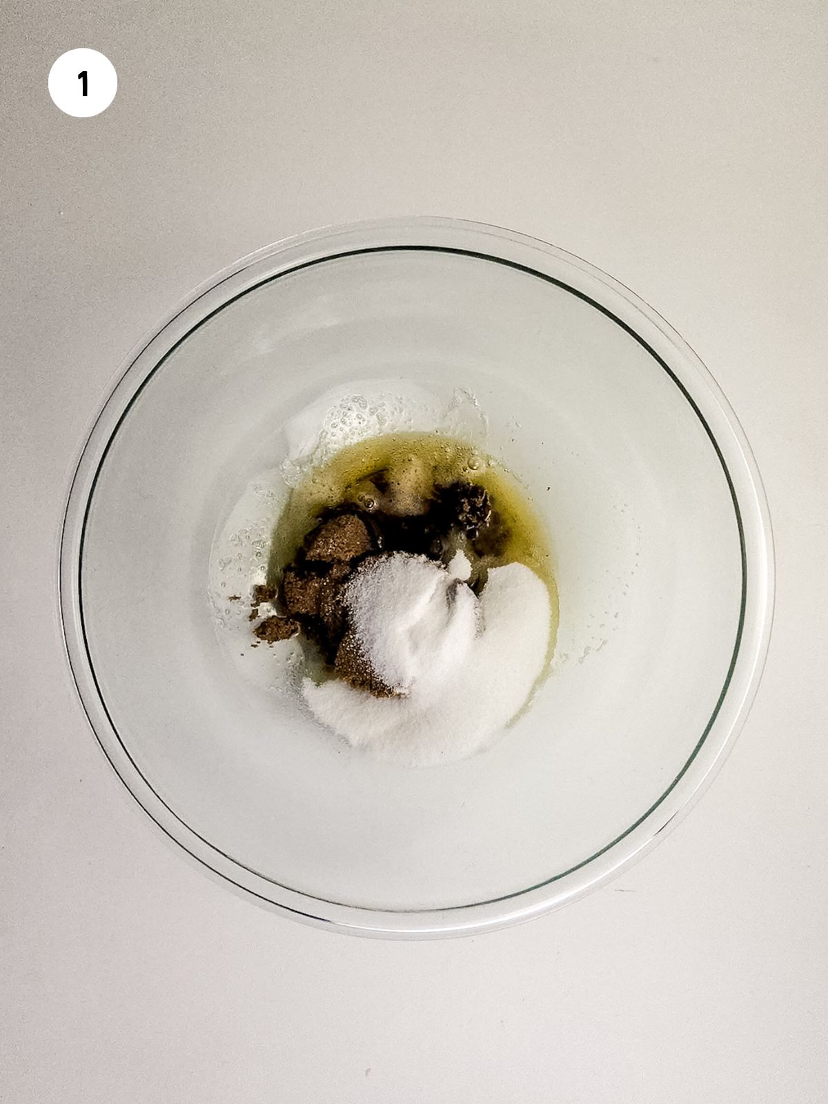 Melted butter, brown and white sugar in a clear mixing bowl.
