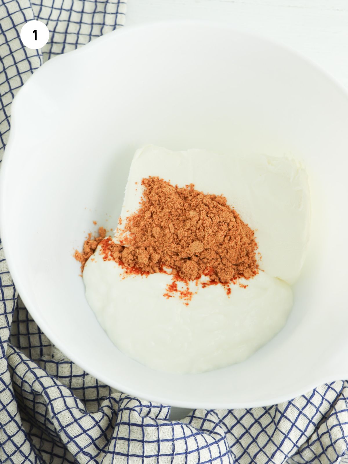 cream cheese, sour cream, and taco seasoning in a white mixing bowl