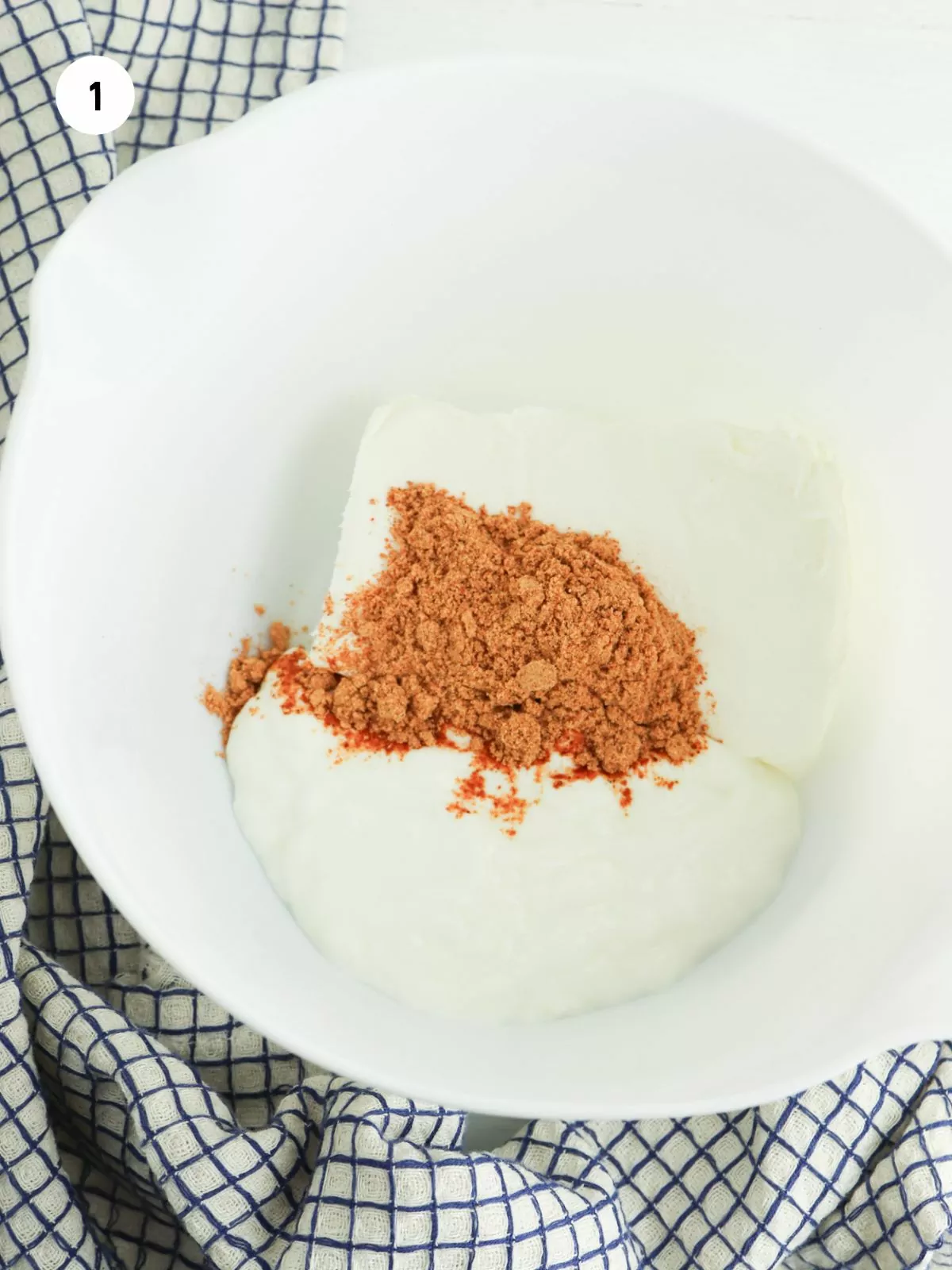 cream cheese, sour cream, and taco seasoning in a white mixing bowl
