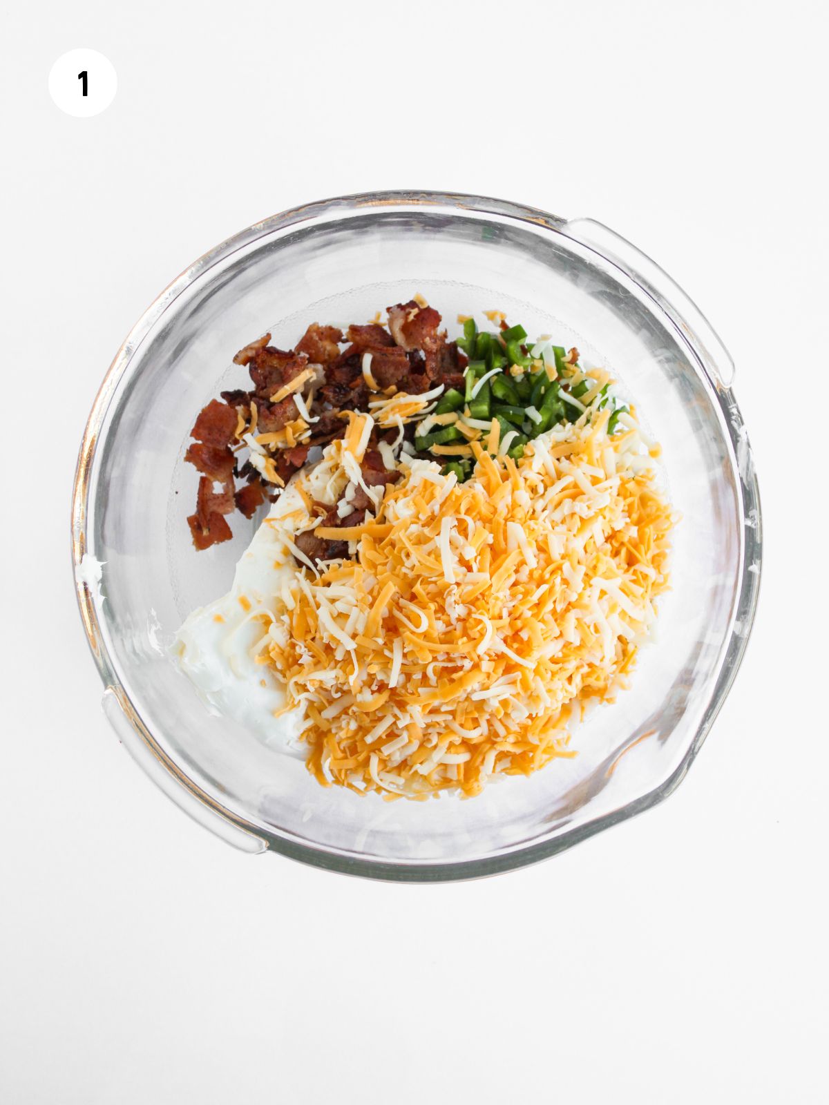 shredded cheese, cream cheese, bacon, and jalapenos in a mixing bowl