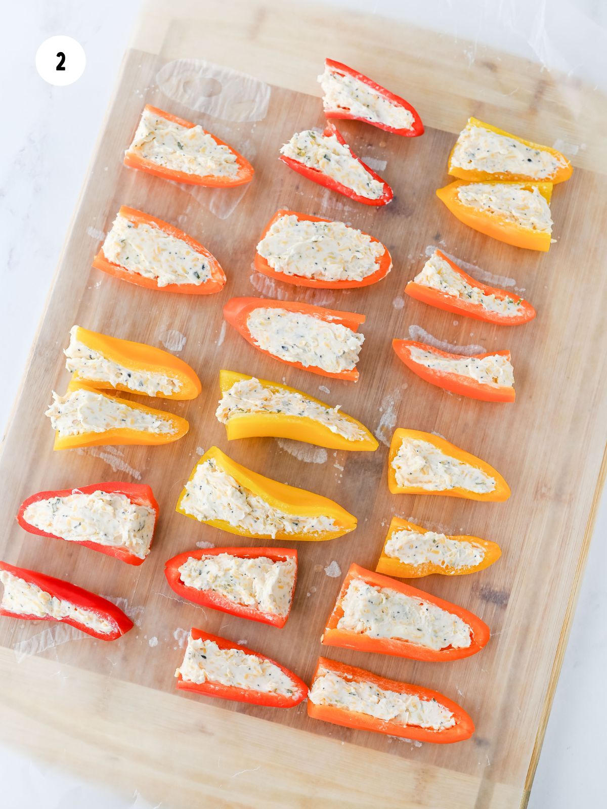 cream cheese filled peppers on a cutting board