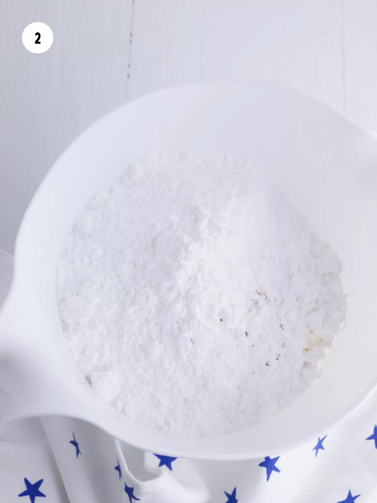 Ingredients for the frosting in a white mixing bowl.