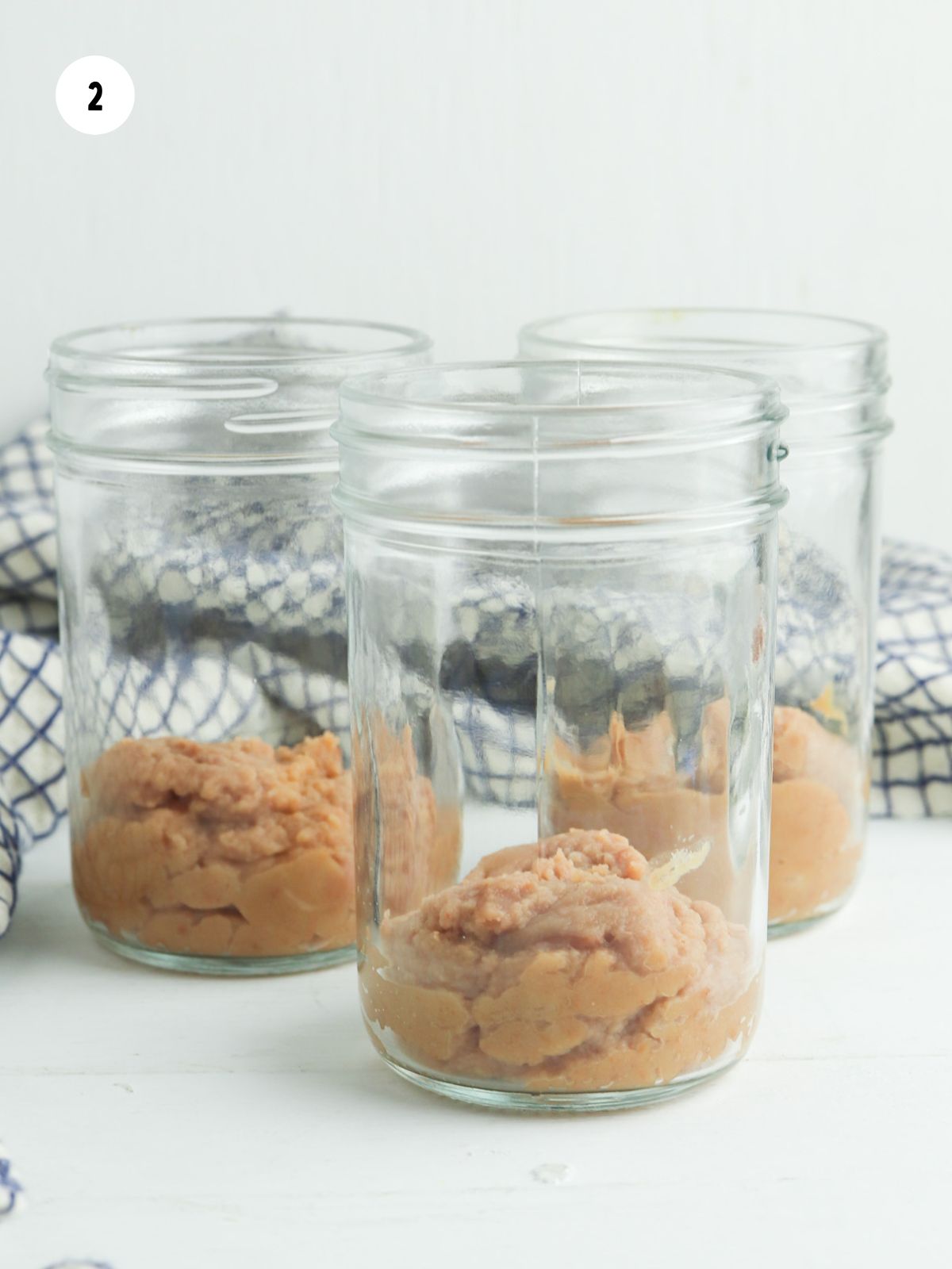 refried beans layered in the bottom of a mason jar