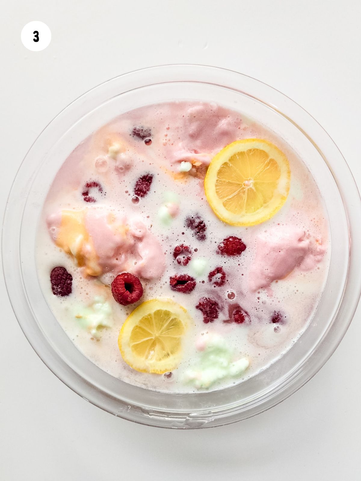 raspberries and lemon slices added to the punch