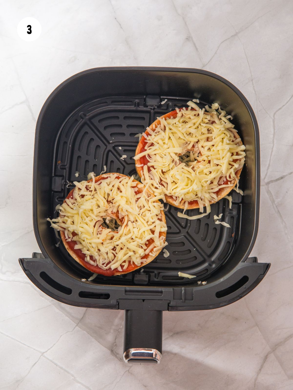 Mozzarella added on top of the pizza sauce.