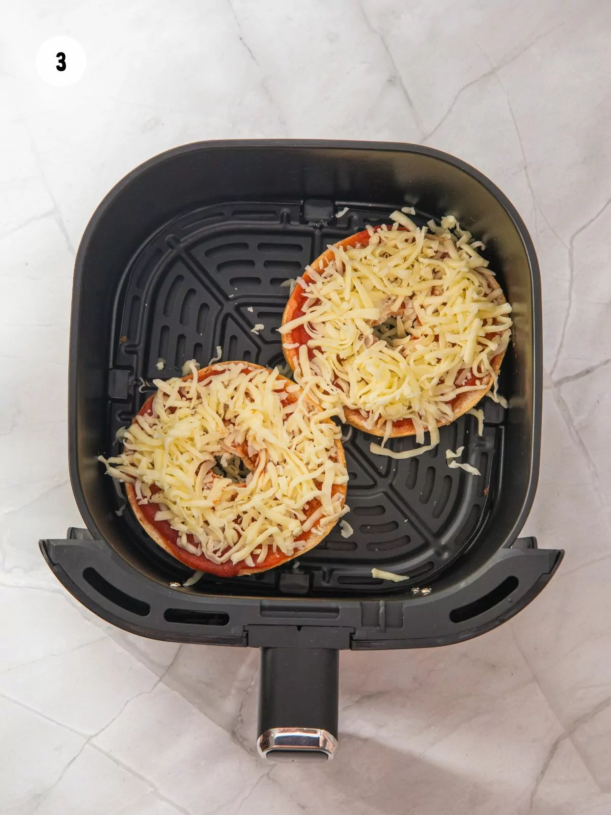 Mozzarella added on top of the pizza sauce.