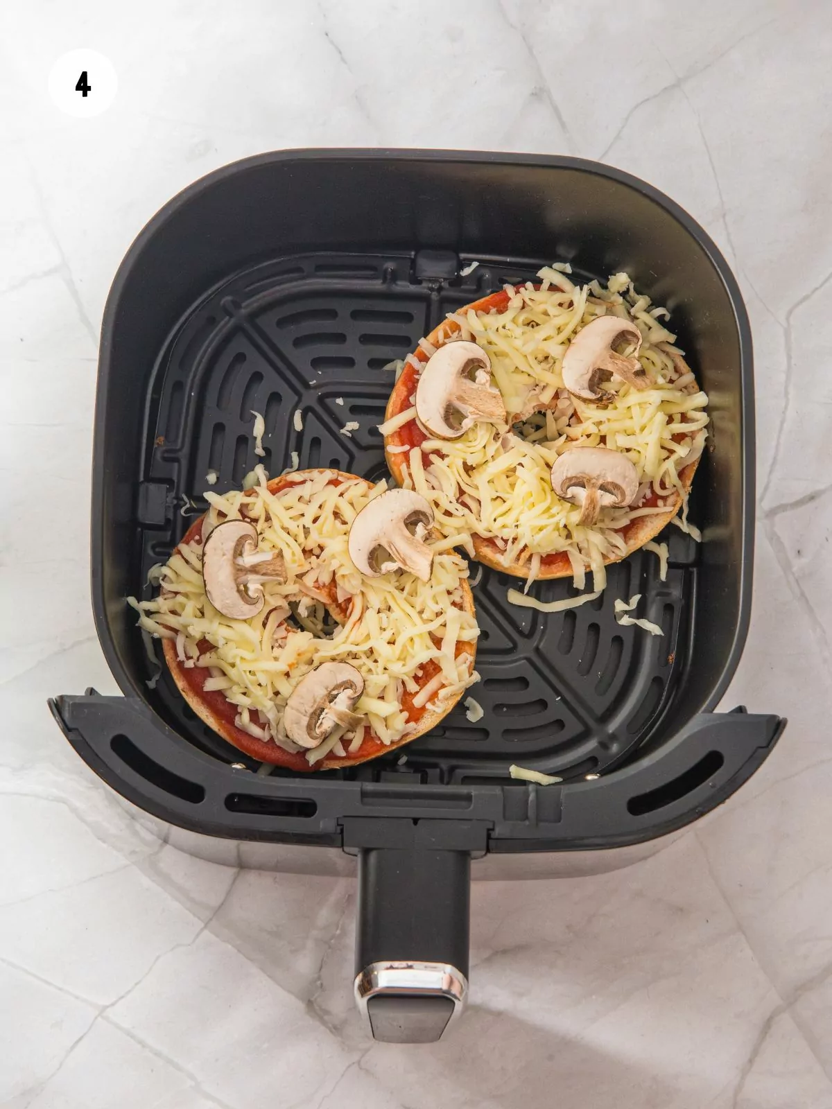 Sliced mushrooms placed on top of the mozzarella.