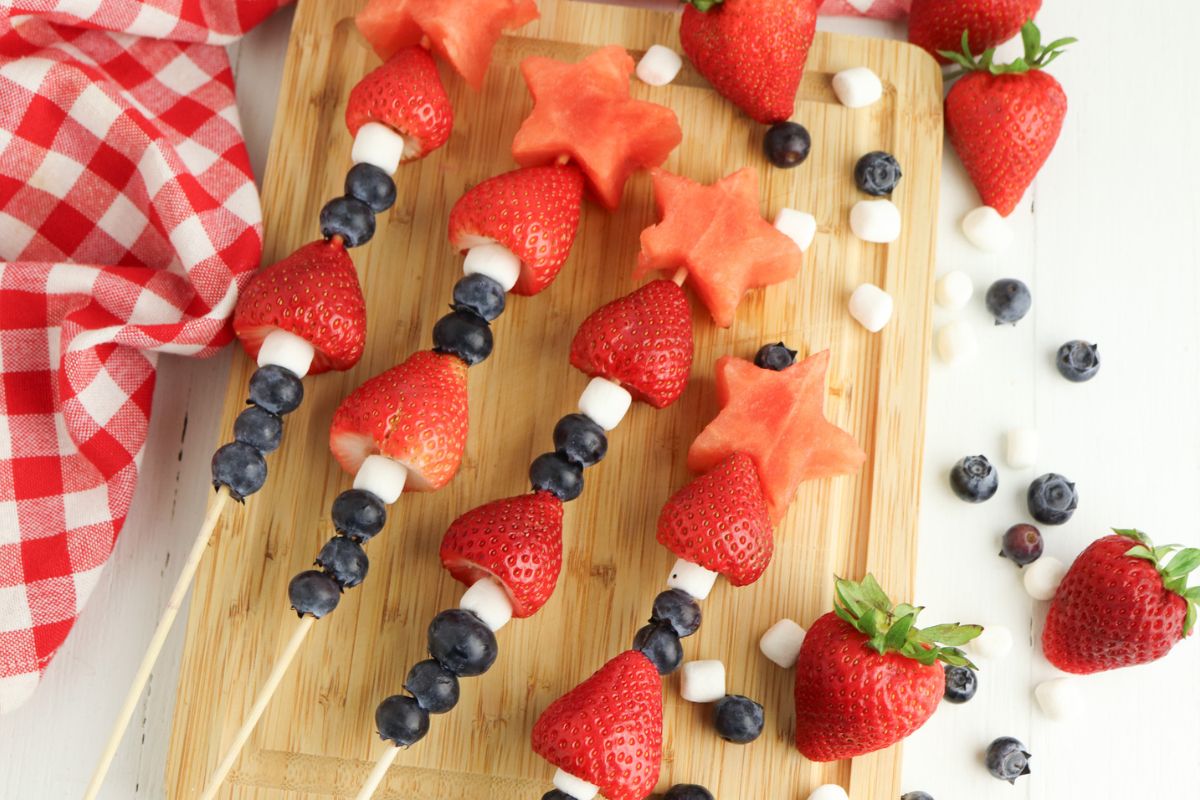 Kabobs made with blueberries, mini marshmallows, strawberries, and star shaped watermelon.