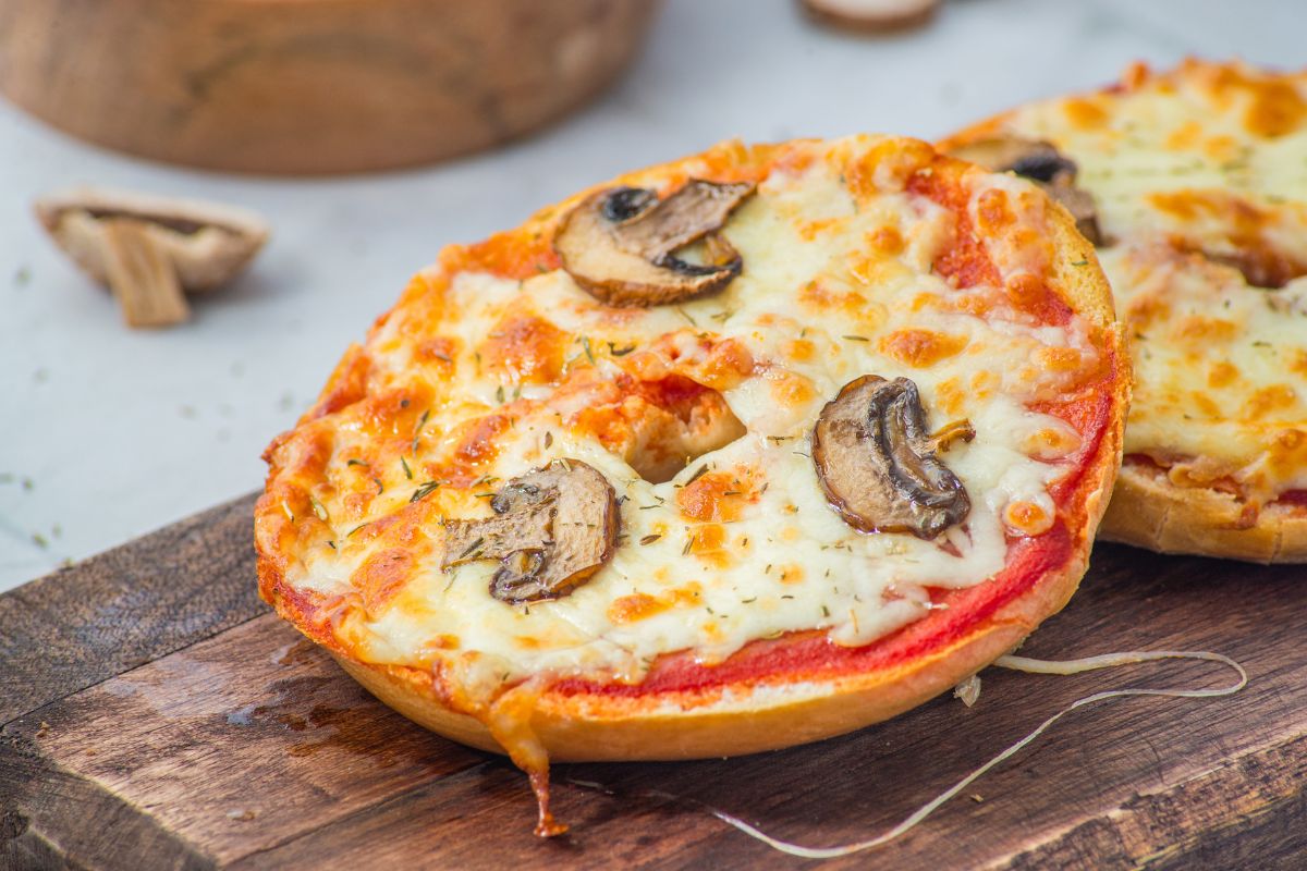 Bagel pizzas topped with mozzarella and mushrooms.