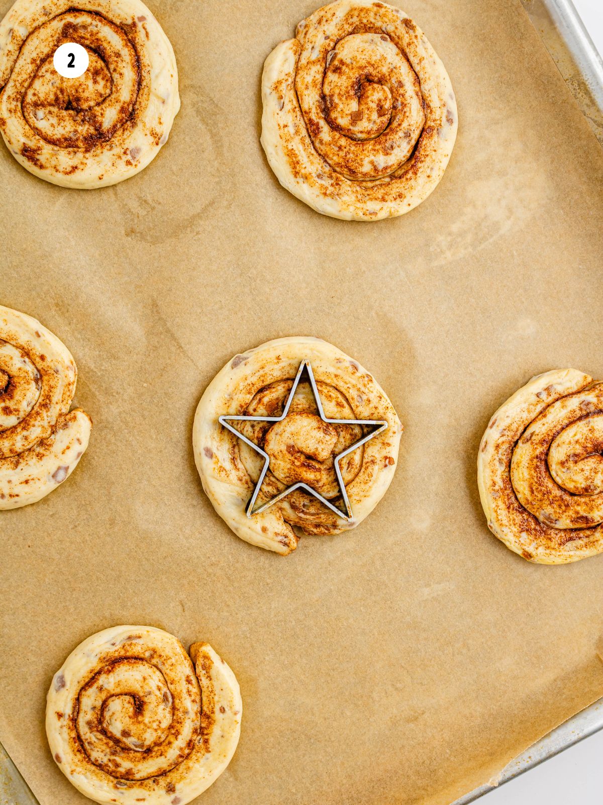 flattened cinnamon rolls with star shaped cookie cutter in center of one.