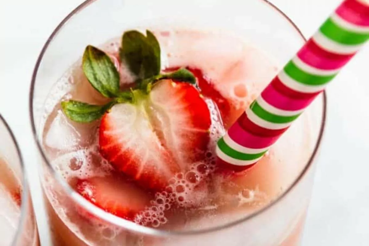 glass of pink drink with strawberry