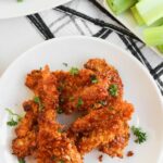 Overhead view of a plate of air fried chicken tenders coated in honey bbq.