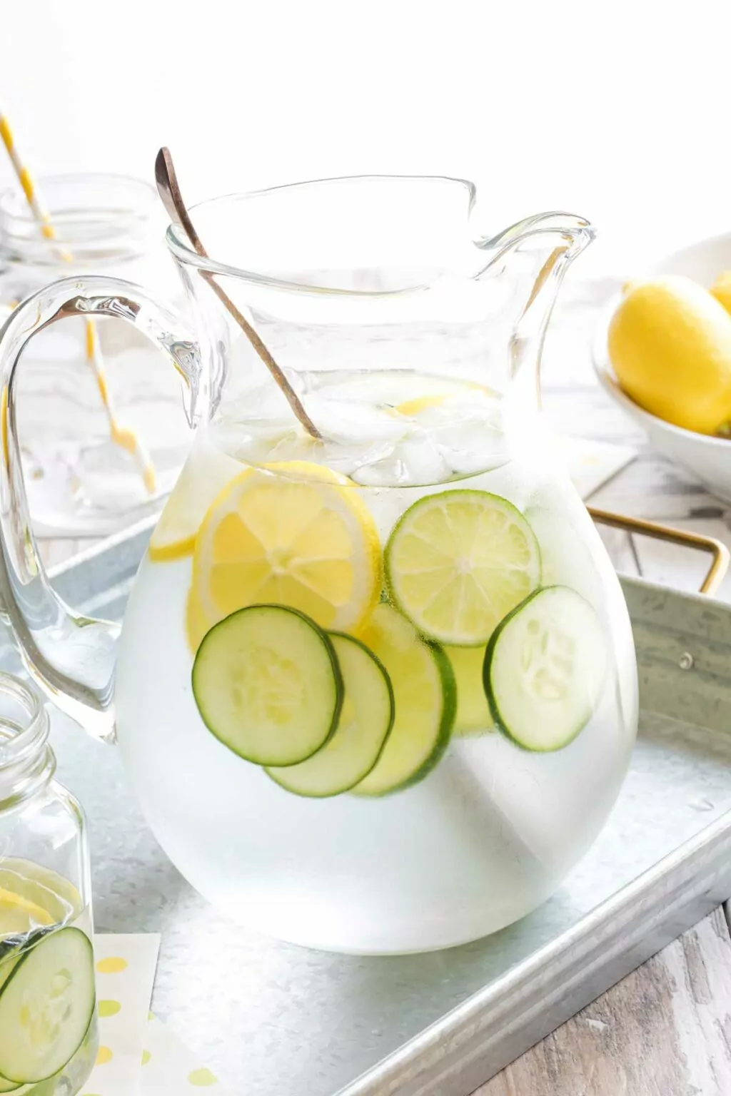 pitcher of water with slice of lemon and lime