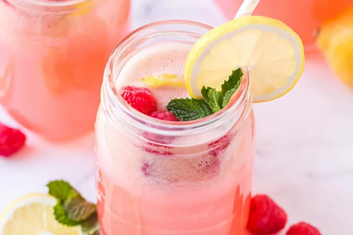 glass of Raspberry Lemonade with raspberry, mint and lemon toppings