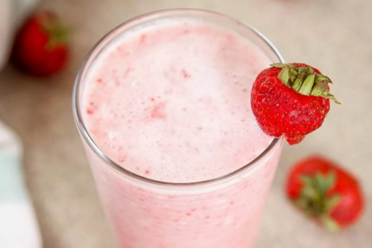 glass of Starbucks Pink Drink with strawberry at the side of the glass
