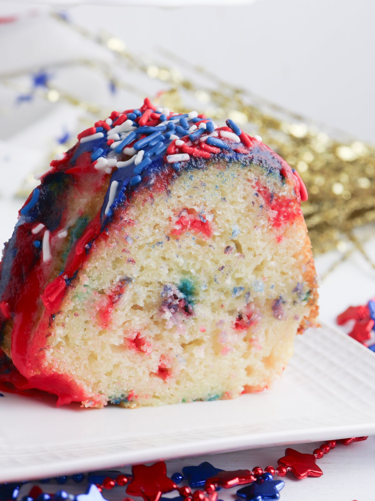 Slice of red and blue confetti cake with red white and blue sprinkles.