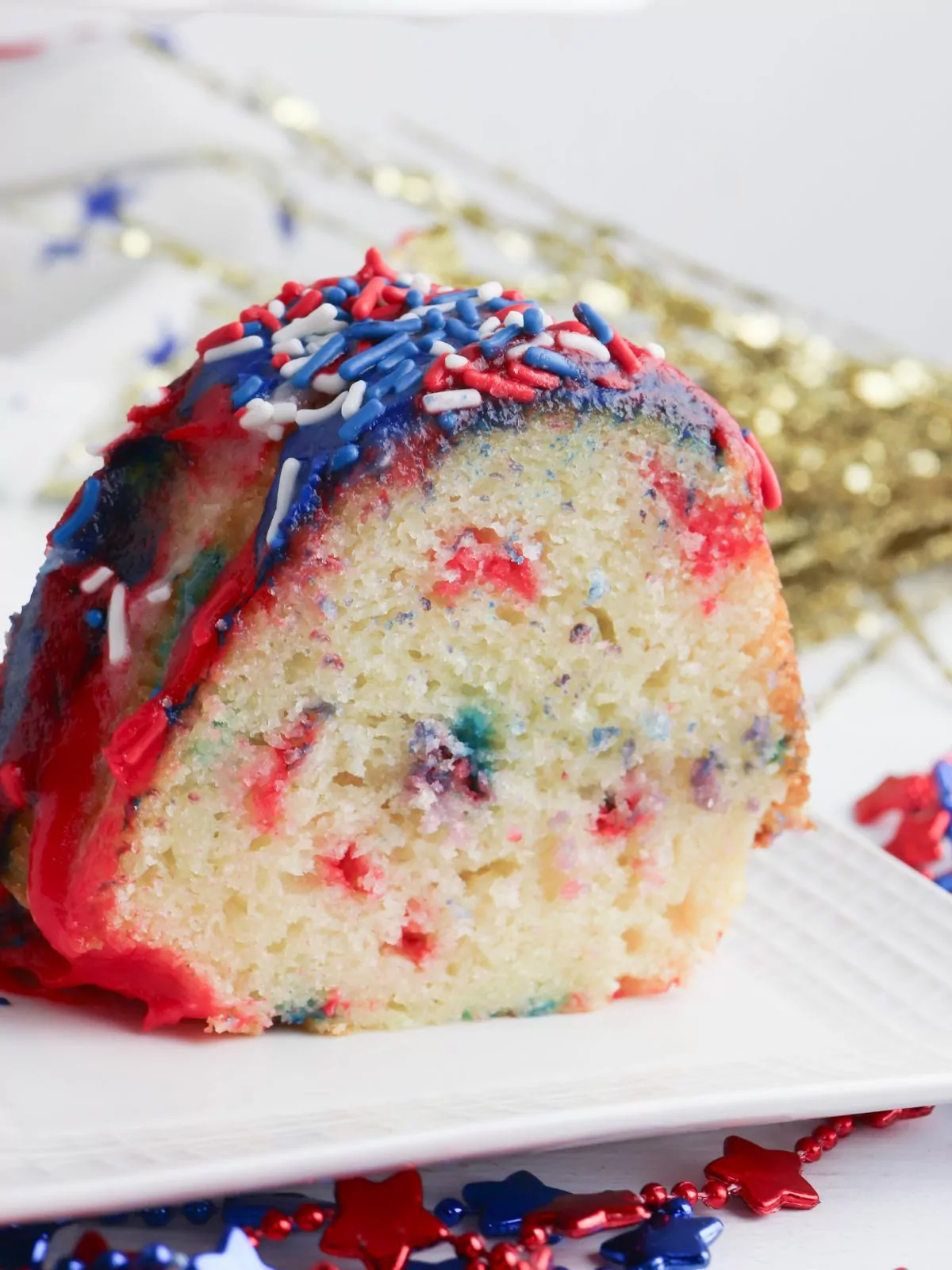 Slice of red and blue confetti cake with red white and blue sprinkles.