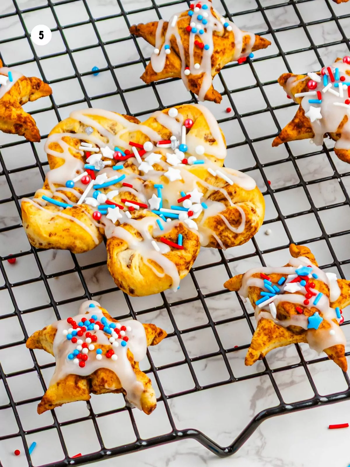 decorated refrigerated cinnamon rolls with icing and red, white and blue sprinkles.