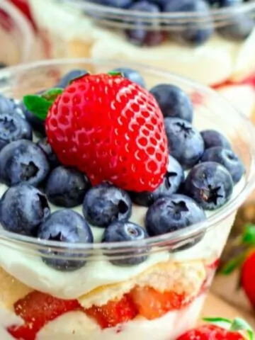 Individual pudding trifle topped with blueberries and strawberries.