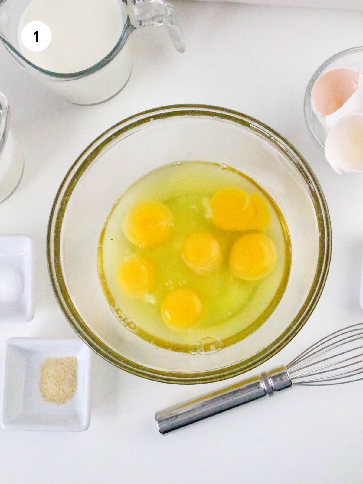 Cracked eggs in a clear mixing bowl.