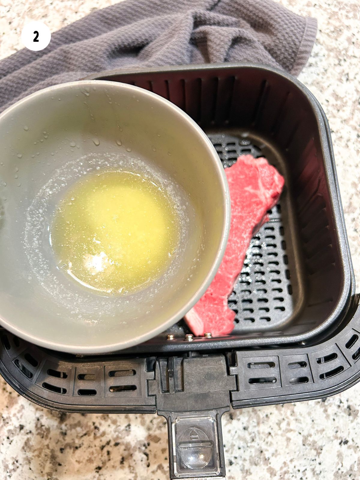 Bowl of melted butter to be brushed on the steaks.