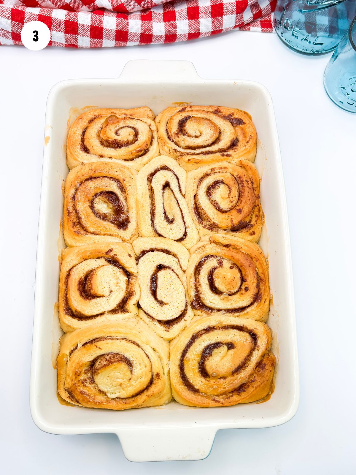 Dish filled with baked cinnamon rolls.