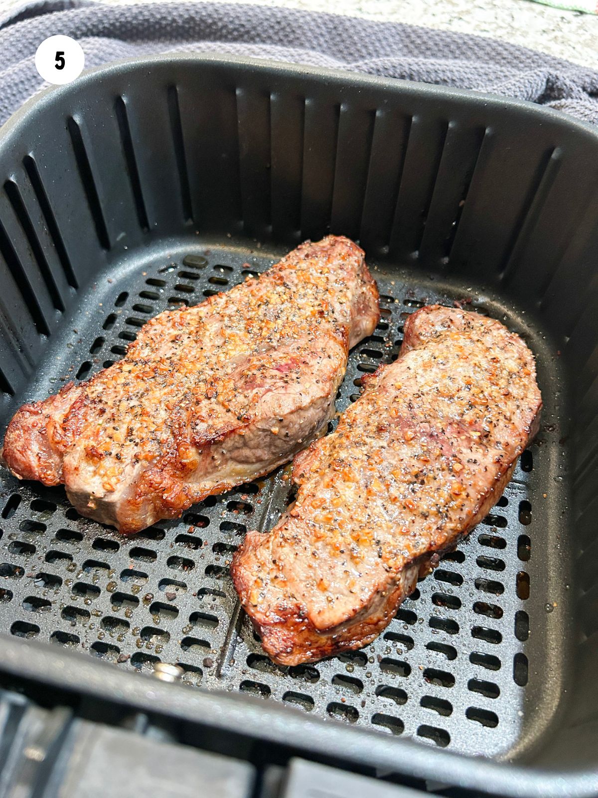 Finished steaks in air fryer basked.