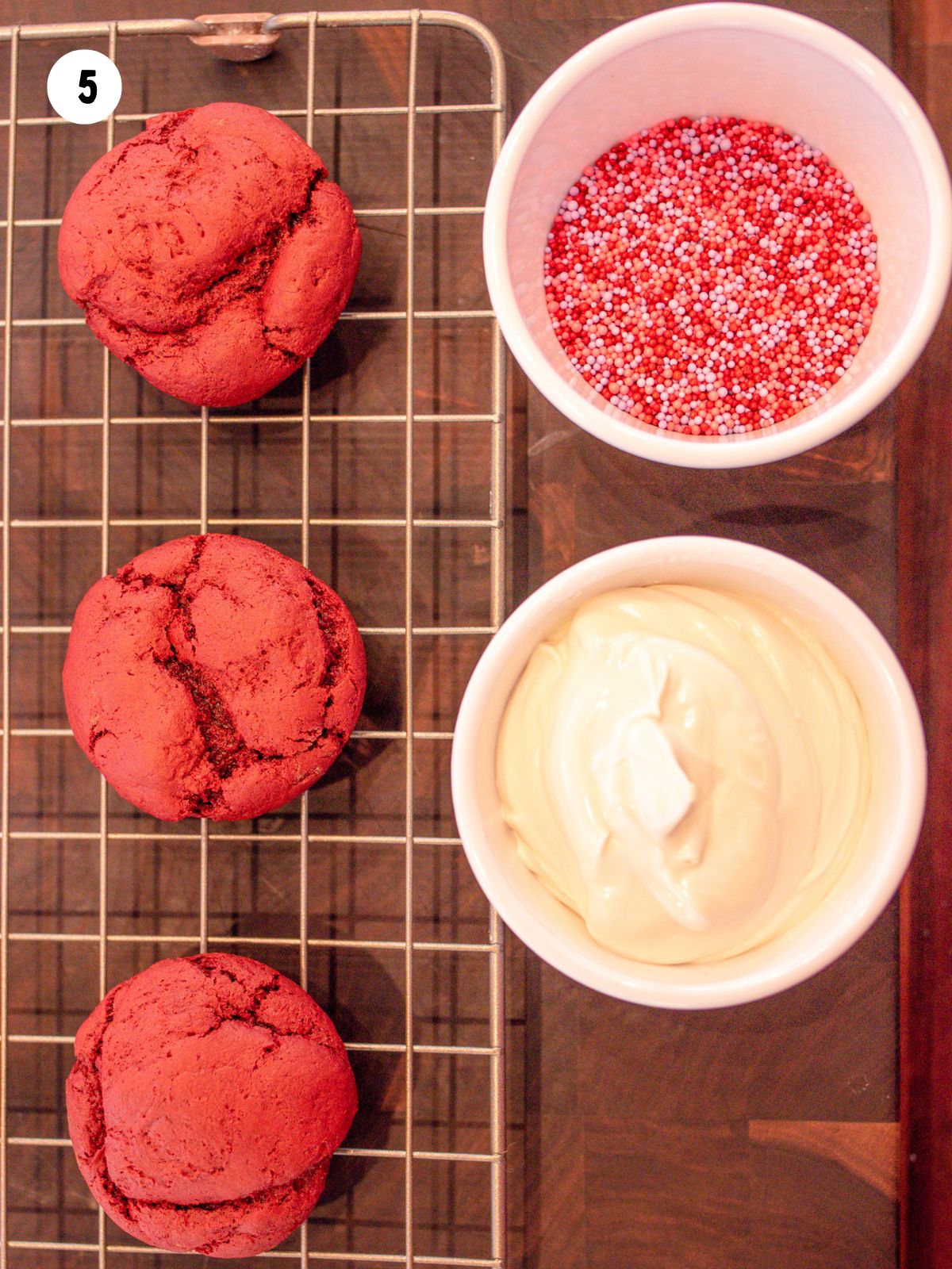 baked cookies next to melted chocolate and sprinkles in separate bowls.