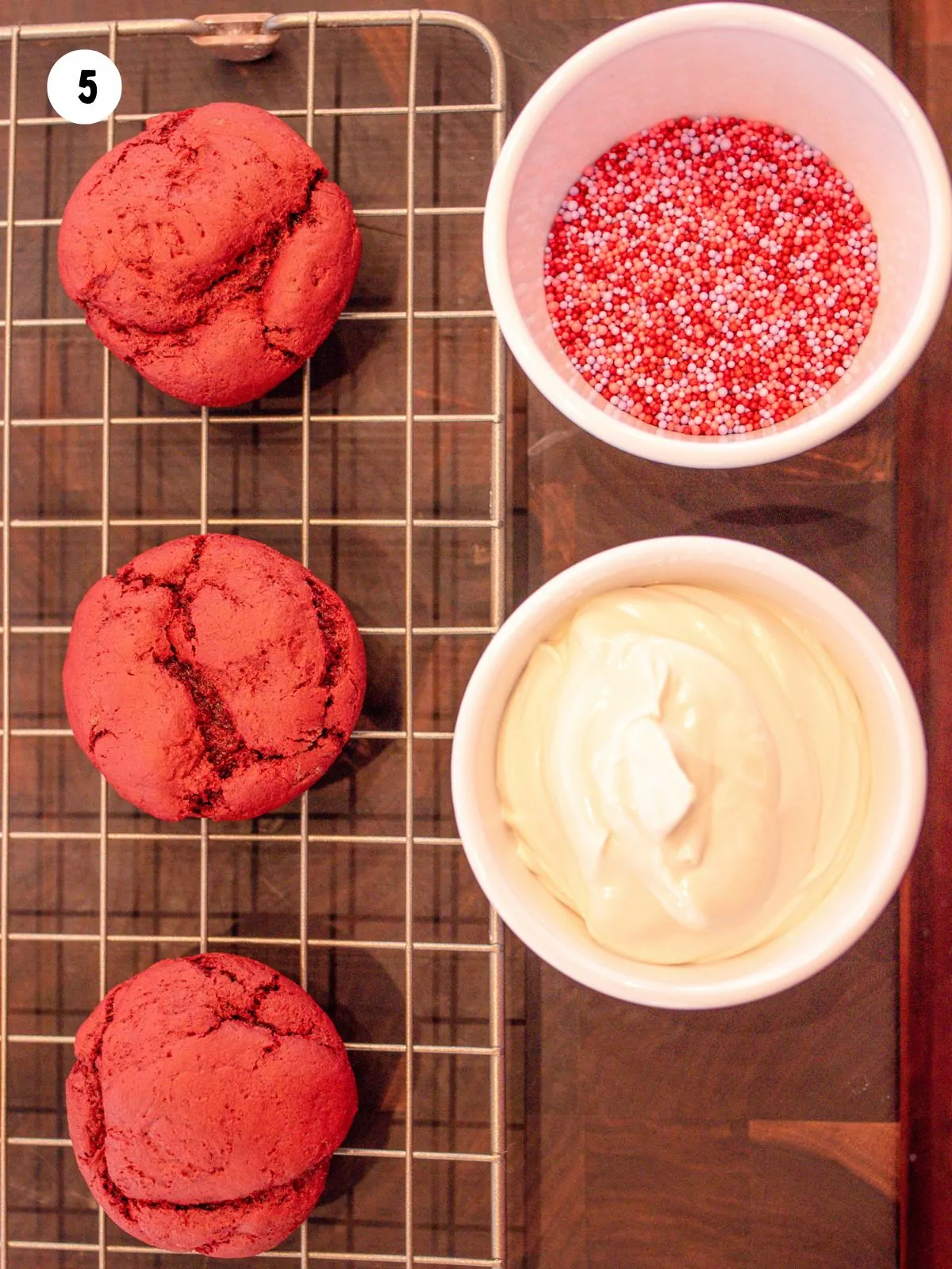 baked cookies next to melted chocolate and sprinkles in separate bowls.